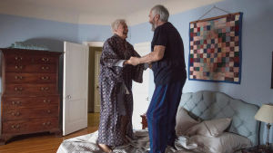 Jag har vunnit Nobelpriset! Joe (Jonathan Pryce) och Joan (Glenn Close) hoppar av glädje. Joan (Glenn Close) och Joe (Jonathan Pryce) håller varandra i händerna och hoppar på sängen av glädje.