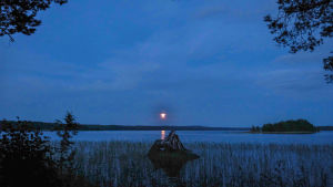 Auringonlasku Sumiaisjärvellä. Sinertävä tyyni järvenselkä, auringonlasku.