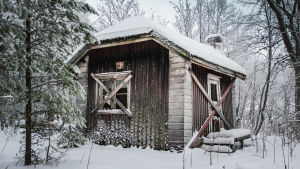 Täältä on lähdetty ilman aikomusta palata. Autiotalo, laudat ikkunoissa, lunta katolla ja maassa.