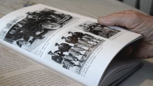Bilderna är många, främst på personer som inte längre finns med oss annat än i minnet. En hand som håller i en sida i boken Det sista brukssamhället.