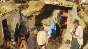 Pelkistetty Natività (Jeesuksen syntymä) Roberto Vanadian sisilialaisessa jouluseimessä Il Presepe nel borgo (Seimikuvaelma kylässä). Yksityiskohta pelkistetystä sisilialaisesta jouluseimestä: Pyhä perhe savimajassa, ympärillä aasi, kyläläisiä ja pillipiipari.