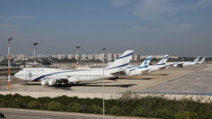 Israels största flygplats Ben Gurion på måndagen. Passagerartrafiken stoppas vid midnatt. Flygplan med flygbolaget El Als markeringar parkerade på en flygplatsplatta med en rad vita höghus i bakgrunden.
