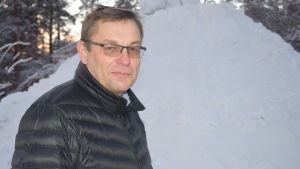 Henrik Westerlund har begärt in en kostnadskalkyl för vad det skulle kosta att bland annat lappa ett läckande tak. En man står ute iklädd vinterjacka. Bakom en stor snöhög.