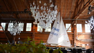 Mat och konst. Festsupén under Food and Art ordnas i en av Åbo båtvarvs stora festsalar. En stor festsal med en segelbåt med hissade segel. I taket hänger konstverk som ser ut som mängder av små segelbåtar.
