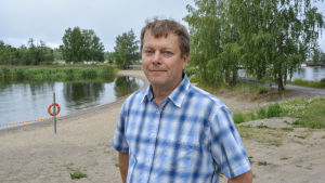 Esa Hirvijärvi, miljöinpektör vid Vasa stad. Esa Hirvijärvi, miljöinspektör vid Vasa stad, står vid badstranden på Smulterö.