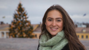 Ingrid Enckell är Finlands lucia 2020. Porträttbild på Finlands lucia framför en julgran.