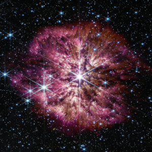 Tähdestä avaruusteleskoopilla otettu kuva juuri ennen supernovaa eli valtavaa räjähdystä. Tähden ympärillä on lilaa tähtipölyä.