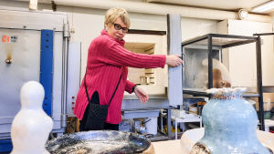 Hellman bränner ofta sina keramikföremål flera gånger innan de är klara. En av de intressantaste sakerna med keramiken är att slutresultatet inte helt går att styra. Vad som kommer ut ur ugnen är alltid lite av en överraskning. En kvinna i pink tröja öppnar dörren till en keramikugn. Framför henne på bordet står keramik.
