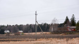 Om elnätet går över en åker där inga grenar kan ta i ledningen så byts den inte ut. Men ska ett nytt bostadsområde byggas på åkern kan det vara dags att ta fram spaden. En elstolpe mitt på en åker.