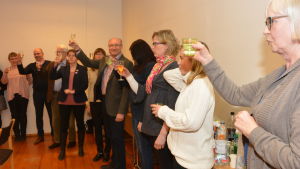 SFP i Ingå skålade i champagne över det goda resultatet. Flera människor står och skålar med champagneglas i händerna.