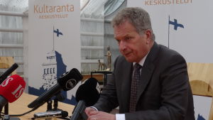 Sauli Niinistö sitter vid bord med mikrofoner på Gullrandamöte