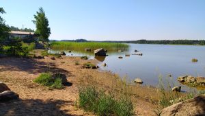 Pyttis är en havsnära kommun. Lököre. Hav i bakgrunden och sandstrand i förgrunden i soligt väder.