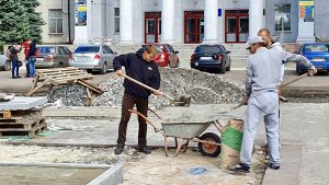 Utanför universitetet gör stadens arbetare parken vackrare. Utanför Donetsk nationella tekniska universitet i Pokrovsk gör stadens arbetare parken vackrare.