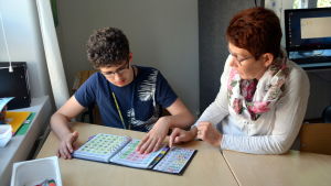 Nina Tikander undervisar idag Wiktor Podolyan. Wiktor Podolyan och Nina Tikander kommunicerar med hjälp av bilder.