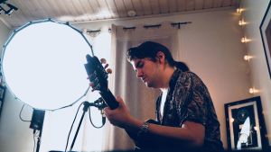 André Linmans hem förvandlades till en ministudio. Musikern André Linman spelar gitarr under starkt ljus hemma hos sig.
