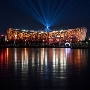 Bild på upplysta Nationalstadion i Peking, som även kallas fågelboet.
