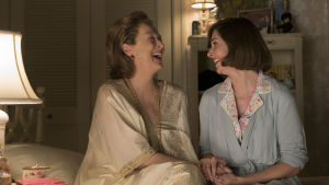 Kay Graham (Meryl Streep) tillsammans med dottern Lally Graham (Alison Brie). Katharine Graham (Meryl Streep) och dottern Lally Graham (Alison Brie) sitter bredvid varandra på sängen och skrattar.