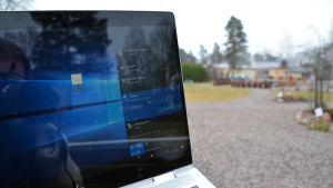 Det går smärtfritt att ta med sig arbetet till Klockarparken, åtminstone när det kommer till nätuppkopplingen. Vad gäller vädret har man inte alltid lika bra tur. Närbild på en bärbar dator med en park i bakgrunden.