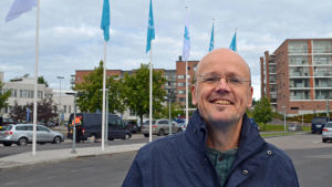 Jan-Erik Mansikka tycker det är viktigt att tala om pojkars framgång i skolan. Universitetslektor Jan-Erik Mansikka poserar framför flaggor på Yles parkeringsplats.