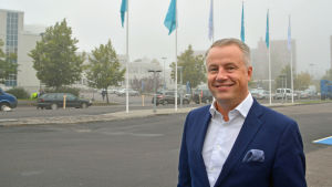 Stadsstyrelseledamot Marcus Rantala anser att beslutet om att sälja är logiskt, då Konstsamfundet redan med Amos Rex bevisat att de vet hur man bedriver affärer i Glaspalatset. Marcus Rantala poserar framför en rad flaggstänger. Dimma i bakgrunden.