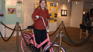 Jopo är en symbol för skoleleverna i Hangö, säger museichef Laura Lotta Andersson. Laura Lotta Andersson står vid en jopocykel.