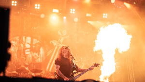 Slayer för sista gången i Finland. Tom Araya på scenen med Slayer. I bakgrunden är det stora eldsflammor från pyrotekniken.