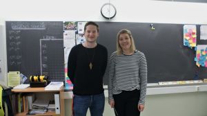 Jimmy Svartström och Jasmin Bilenberg tycker det är trevligt att lärarna samlats för att hjälpa varandra och planera tillsammans. Jimmy Svartström och Jasmin Bilenberg står framför griffeltavlan i ett klassrum.