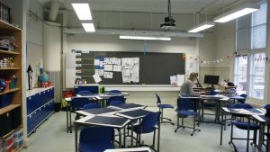 Ännu i tisdags var en del elever på plats i skolan. Nu är det bara klassläraren i klassrummet. Jasmin Bilenberg sitter i ett tomt klassrum och håller distansundervisning med hjälp av en dator.