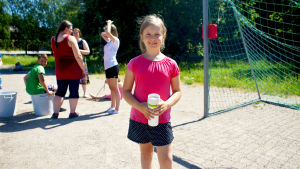 Jessica Martikainen står på en sandplan med en vattenflaska i handen.