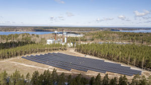 Raseborgs energis värmecentral finns intill solparken. Bakom parken finns flera industrier. Solpaneler i Björknäs i Ekenäs.