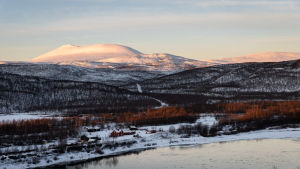 Utsjoki med Tana älv och Rastigaisa-fjället står i centrum för handlingen i romanen "Halla Helle". Näkymä Tenojoen yli kohti Finnmarkin puolella nousevaa Rastigaisa-tunturia.