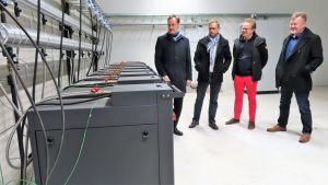 I elbolaget Vatajakoskis fjärrvärmehall står tio dataservrar på rad. Servrarna kyls ner av vatten och vattnet som värms upp utnyttjas i sin tur i fjärrvärmenätet. På bild från vänster vd Pekka Passi, vd Kari Koivisto, utvecklingschef Akseli Reho och operativ chef Marko Niskanen. Tietokonepalvelimia kaukolämpöverkossa