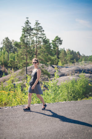 Hellström säger att hon tycker det är roligt att promenera i vilket väder som helst, inte bara i gnistrande solsken. "Jag får se olika stadsdelar i olika väder och under olika årstider", säger hon. En gladkvinna promenerar för en asfalterad gata. I bakgrunden synds träd.