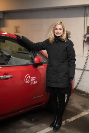 Esbos trafikstyrnignschef Johanna Nyberg säger att hon pendlar till kontoret i Esbo centrum från Helsingfors. Hon brukar ändå oftast använda sig av kollektivtrafiken. En kvinna står brevid en röd bil. Hon ser in i kameran. Bilen och kvinnan står i ett parkeringsgarage.