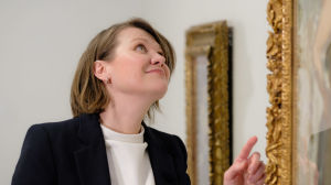 Sara Hildenin taidemuseon kokoelmapäällikkö Maria Laine tutkii koristeellista kullattua kehystä. 