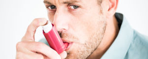 Fuktskador i byggnader kan leda till astma och andningssvårigheter. Illustrerande bild. Man andas via inhalator.