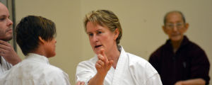 Emma Wester, Marie Kellett och sensei Harada. Emma Wester och Marie Kellett diskuterar. I bakgrunden skymtar sensei Harada.