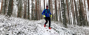 Mikko Peltola juoksee metsässä.