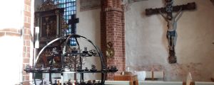 Pargas kyrka erbjuder samtalsstöd på måndagen. insidan i pargas kyrka - syns jesus på korset och ljusställning i metall
