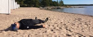 Mikko Peltola makaa Hangossa rantahiekalla.