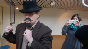 Utställningen Kravatter och kalsonger läggs ut på Facebook. Museipedagog Susanna Louneva fotar museichef Dan Lindholm för Facebook.
