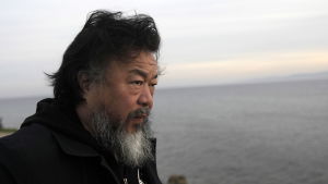 Finns här några flyktingar? Ai Weiwei blickar ut över Medelhavet från Lesbos strand. Ai Weiwei på Lesbos