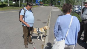 Kenneth Ekholm och hans ledarhund Assar testar trottoarkanterna vid Nickby hälsovårdscentral Kenneth Ekholm och hans ledarhund Assar testar trottoarkanterna vid Nickby hälsovårdscentral