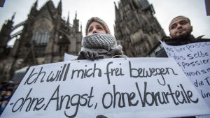 En kvinna i Köln demonstrerar mot sexuellt våld och håller upp en skylt med texten"Jag vill röra mig fritt, utan rädsla, utan fördomar"