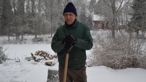 Gösta Lundén. En man står lutad mot en snöskyffel med snöig bakgrund. Han heter Gösta Lundén.