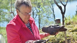 Lena Selén granskar gamla skor som har hittats i Svenviken i Ingå