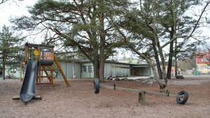 Hnagonkylän koulu i Hangö. Rutschkana på en skolgård. I bakgrunden skymtar Hangonkylän koulu i Hangö.