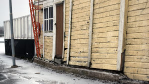 Ena väggen lutar och fasaden skulle behöva en omgång målarfärg. En fasad i dåligt skick.