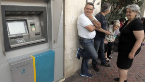 Regeringen i Grekland införde uttagsgränser förra veckan. Greker har bildat en kö till en bankautomat i väntan på att automaterna ska börja fungera igen.