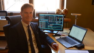 Lars Lönnblad lars lönnblad sitter vid sitt skrivbord och har aktiekurser i bakgrunden på sin dataskärm